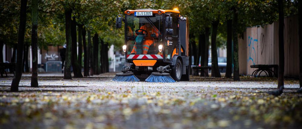 Eine Kehrmaschine der Berliner Stadtreinigung beseitigt Laub am Gendarmenmarkt.