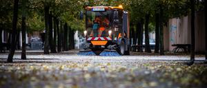 Eine Kehrmaschine der Berliner Stadtreinigung beseitigt Laub am Gendarmenmarkt. 
