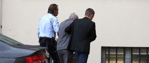 Der frühere SS-Wachmann Reinhold Hanning (M) wird von seinem Sohn und einem Justizbeamten in das Landgericht geführt.