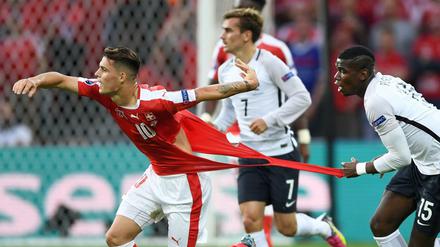 Der Franzose Paul Pogba (links) versucht den Schweizer Granit Xhaka am Trikot festzuhalten und zerreißt es dabei. 