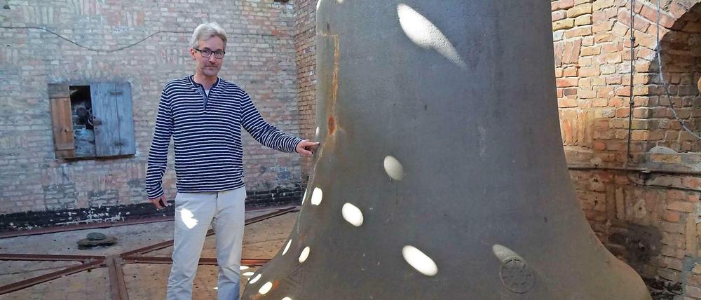 Pfarrer Andreas Groß deutet auf die Schramme an der Glocke, die beim Absturz im Mai 2008 ansonsten intakt blieb.