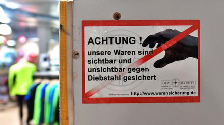 Ein Schild im Einzelhandel weist auf die Sicherung der Ware hin. Diebe lassen sich davon nicht beeindrucken.