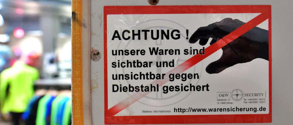 Ein Schild im Einzelhandel weist auf die Sicherung der Ware hin. Diebe lassen sich davon nicht beeindrucken.