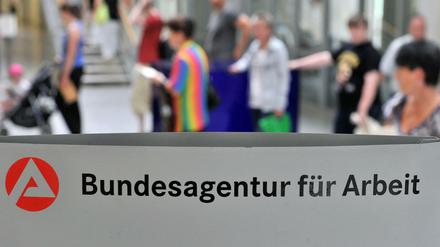 Kunden der Agentur für Arbeit in Leipzig warten an einem Schalter.