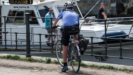 Vorbildlich. Helm auf, Fahrrad mit allem drum und dran: Hier macht ein Polizist auf seinem Rad an der Spree in der Sonne Pause. In Deutschland läuft alles auch im Straßenverkehr nach klaren Regeln, das sollen Geflüchtete jetzt dank einer neuen App "German Road Safety" verinnerlichen.