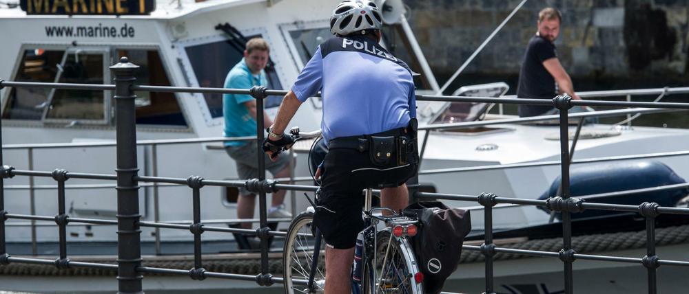 Vorbildlich. Helm auf, Fahrrad mit allem drum und dran: Hier macht ein Polizist auf seinem Rad an der Spree in der Sonne Pause. In Deutschland läuft alles auch im Straßenverkehr nach klaren Regeln, das sollen Geflüchtete jetzt dank einer neuen App "German Road Safety" verinnerlichen.