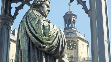 Eine Lutherstatue, im Hintergrund ist eine Kirche zu sehen.