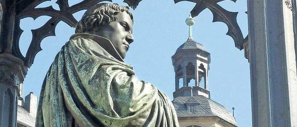 Eine Lutherstatue, im Hintergrund ist eine Kirche zu sehen.