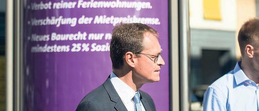 Michael Müller vor einer lila Litfaßsäule mit seinen Miet-Botschaften.