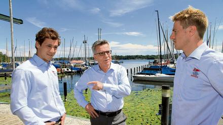 Bundesinnenminister Thomas de Maizière spricht mit den beiden Berliner Olympiaseglern Erik Heil (rechts) und Thomas Plößel (links).