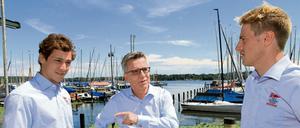 Bundesinnenminister Thomas de Maizière spricht mit den beiden Berliner Olympiaseglern Erik Heil (rechts) und Thomas Plößel (links).