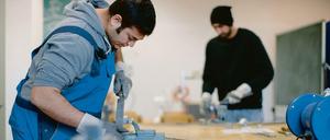 Der afghanische Flüchtling Sha Kah Ahmadi (l.) und der indische Flüchtling Singh Satwinder feilen in der Fortbildungsakademie der Wirtschaft (FAW) in Dresden (Sachen) an Metallwerkstücken. Beide sind zum Probearbeiten da, um deren Kompetenzen auszuloten. 
