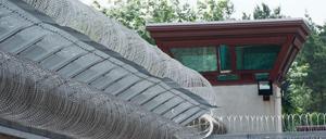 Ein Wachturm überragt die Außenmauer der JVA Tegel.