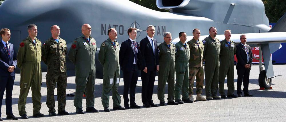 Nato-Generalsekretär Jens Stoltenberg (Mitte) steht mit Offiziellen und Militärführern vor einer Nato-Drohne am Tagungsort des Gipfeltreffens der Nato-Staaten in Warschau. 