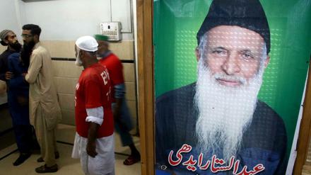 Ein Bild von Abdul Sattar Edhi hängt in einer seiner Einrichtungen, wo Mitarbeiter nach der Todesnachricht trauern.