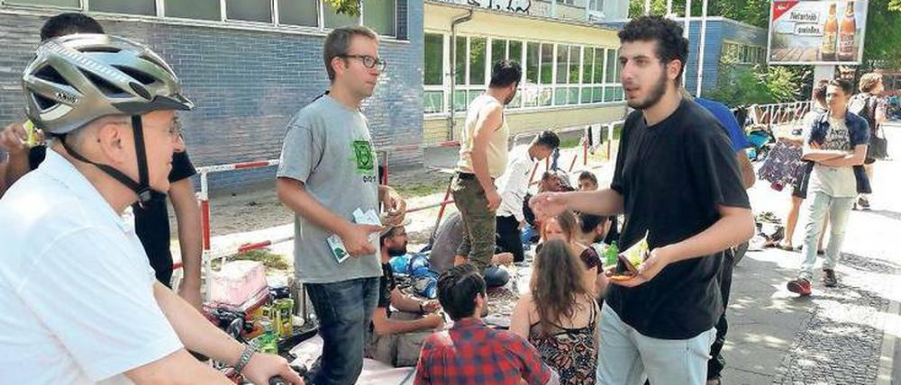 Sit-in vor Turnhalle. Geflüchtete Männer aus Syrien und ihre Unterstützer protestieren gegen den Umzug in die Notunterkunft in den Flughafen-Hangars von Tempelhof. Morgen wollen sie vor das Rathaus Neukölln ziehen.