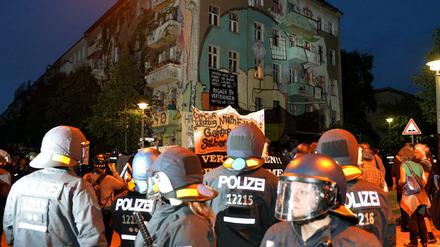 Polizisten stehen vor einem besetzten Haus in der Rigaer Straße.