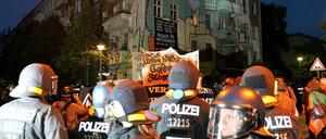 Polizisten stehen vor einem besetzten Haus in der Rigaer Straße.