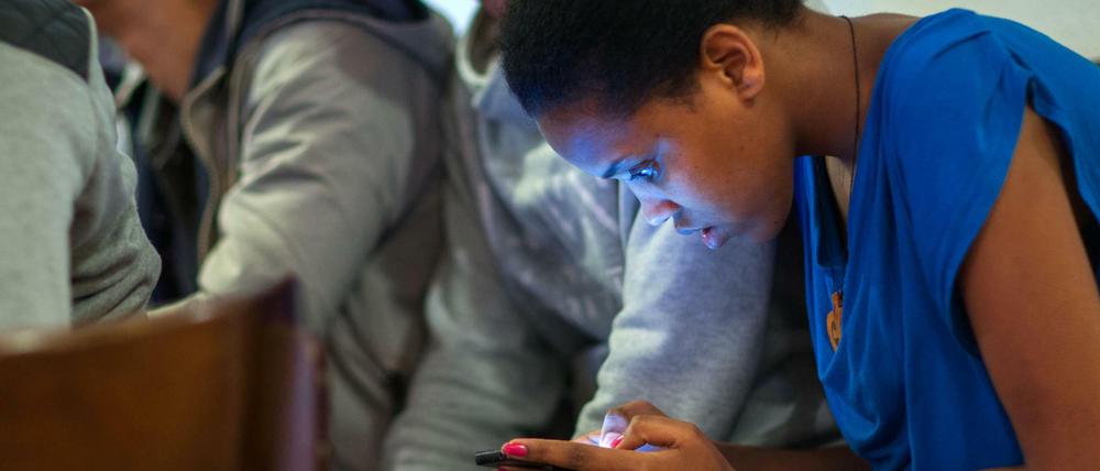 Ein Mädchen aus Eritrea liest in einem Mecklenburger Heim vergangenes Jahr eine Nachricht auf ihrem Smartphone.