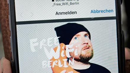 "Free WiFi Berlin" steht auf dem Bildschirm eines Handys am Brandenburger Tor. 