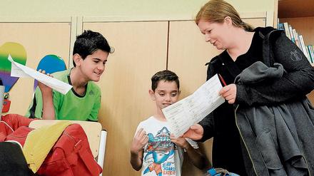 Eine Lehrerin spricht mit zwei Schülern.