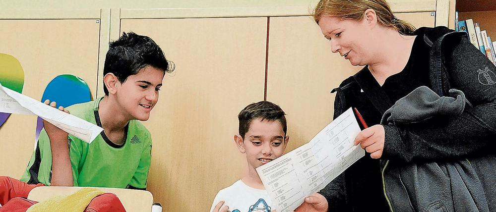 Eine Lehrerin spricht mit zwei Schülern.