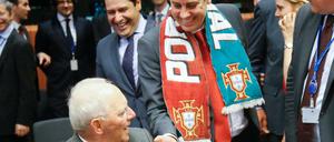 Portugals Finanzminister Mario Centeno mit EM-Siegerschleife begrüßt Wolfgang Schäuble beim Treffen der Euro-Finanzminister.