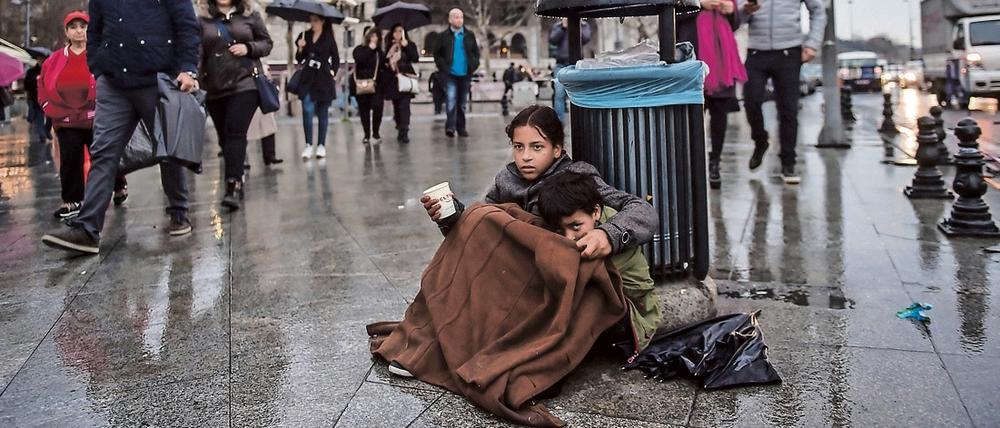 Ein syrisches Mädchen bettelt mit seinem kleinen Bruder in Istanbul.