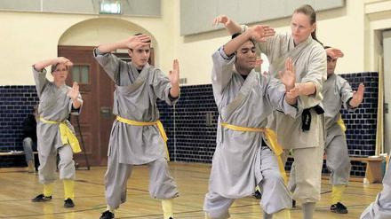Kung-Fu-Weltmeisterin Tatjana Herrmann zeigt dem jungen Afghanen Jan die richtige Haltung. Links neben ihm steht Mohammad, der vor wenigen Monaten nach drei Jahren Flucht Deutschland erreichte. 