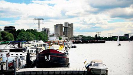 Der Blick von der Marina am Ende des Uferwegs in der Rummelsburger Bucht Richtung Oberschöneweide. Links erhebt sich das Zementwerk Berlin, in der Ferne die Gebäude des Rundfunkgeländes Nalepastraße.