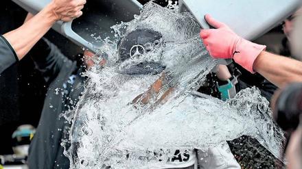 Nass gemacht. Die Teamkollegen von McLaren Mercedes überschütten den britischen Formel-eins-Fahrer Lewis Hamilton mit eimerweise Eiswasser. Hamilton ist nur einer von unzähligen Prominenten, die sich der „Ice Bucket Challenge“ aussetzten, einer viralen „Herausforderung“, die auf die degenerative Nervenkrankheit ALS aufmerksam machen soll. Foto: Reuters