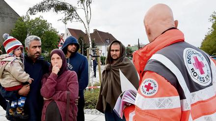 DRK-Helfer mit Flüchtlingen in Eisenhüttenstadt. Anfang des Jahres soll hier eine Kenianerin vergewaltigt worden sein.