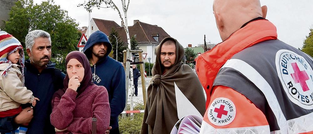 DRK-Helfer mit Flüchtlingen in Eisenhüttenstadt. Anfang des Jahres soll hier eine Kenianerin vergewaltigt worden sein.