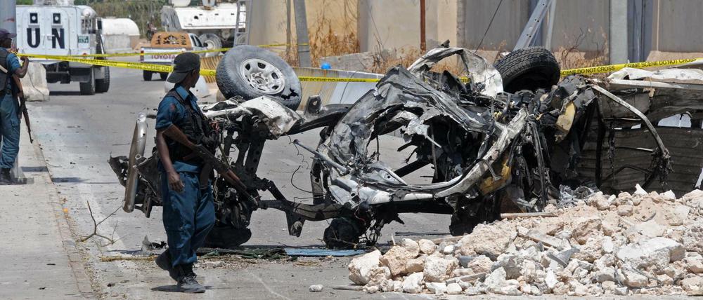 Somalische Soldaten am Wrack eines von einer Bombe zerstörten Autos in Mogadischu.