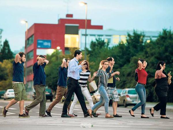 Menschen laufen zum Schutz mit erhobenen Armen weg vom Ort des Geschehens.