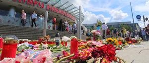 Blumen, Kerzen und Stofftiere liegen am 24.07.2016 vor dem Olympia-Einkaufszentrum in München.