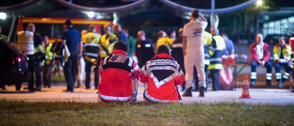 Rettungskräfte sitzen am 23.07.2016 in München (Bayern) an der Kreuzung am Georg-Brauchle-Ring nahe dem Einkaufszentrum, in dem Schüsse gefallen sind. Bei Schüssen am Olympia-Einkaufszentrum in München hat es am Freitag nach Angaben der Polizei Verletzte und mehrere Tote gegeben. 