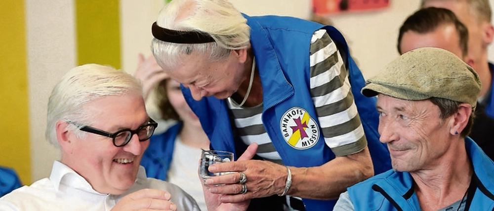 Bundesaußenminister Frank-Walter Steinmeier (SPD) unterhält sich mit einer ehrenamtlichen Mitarbeiterin in der Bahnhofsmission. Rechts sitzt der Leiter der Mission, Dieter Puhl.