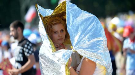 Teilnehmer des Weltjugendtages in Krakau schützen sich vor der Sonne.