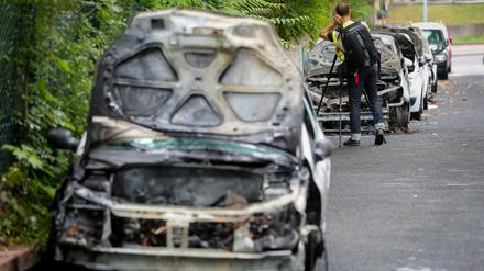 Beamte des Landeskriminalamtes untersuchen ausgebrannte Autos eines Pflegedienstes in Berlin-Steglitz. Insgesamt wurden acht Fahrzeuge angezündet. Foto: Kay Nietfeld/dpa