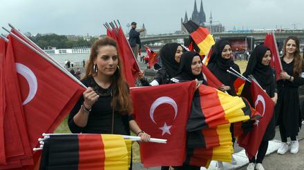 Für die Türkei und für Deutschland: Helferinnen verteilen vor dem Beginn der Kundgebung Fahnen.