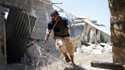 Ein Kämpfer der libyschen Streitkräfte sucht im Kampf um die vom IS gehaltene Stadt Sirte Schutz.