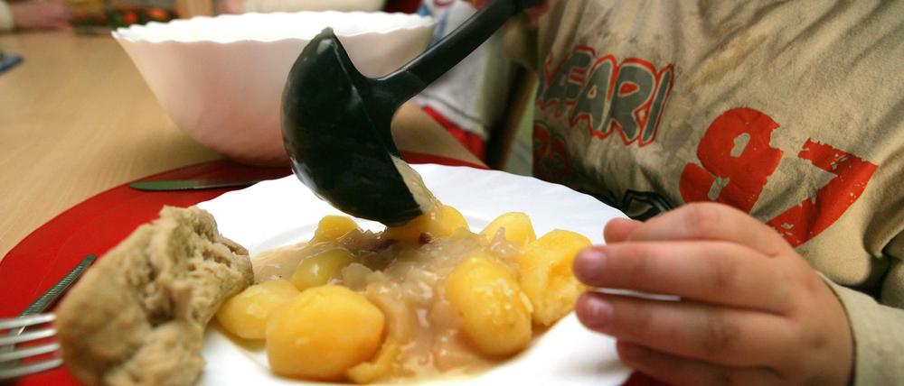 Ein Junge nimmt sich am beim Pädagogischen Mittagstisch des Kinderschutzbundes in Schwerin Soße für die Kartoffeln.