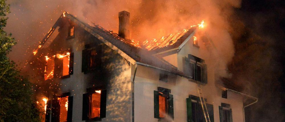 Ein leerstehendes Gebäude, in dem Asylbewerber unterkommen sollten, steht am 24.08.2015 in Weissach im Tal in Baden-Württemberg voll in Flammen.