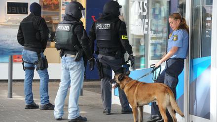 Einsatzkräfte der Polizei warten am 07.08.2016 in der Nähe des Rathauses in Saarbrücken (Saarland) auf ihren Einsatz. In der Innenstadt hat sich der Polizei zufolge ein Bewaffneter in einem Lokal verschanzt. Foto: Becker&amp;Bredel/dpa +++(c) dpa - Bildfunk+++