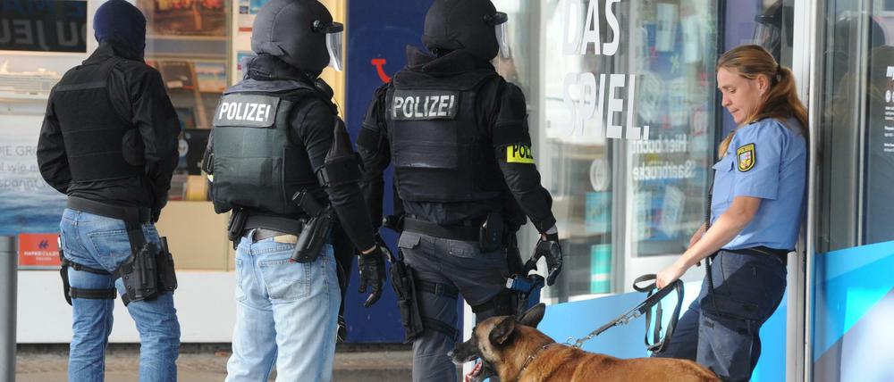 Einsatzkräfte der Polizei warten am 07.08.2016 in der Nähe des Rathauses in Saarbrücken (Saarland) auf ihren Einsatz. In der Innenstadt hat sich der Polizei zufolge ein Bewaffneter in einem Lokal verschanzt. Foto: Becker&Bredel/dpa +++(c) dpa - Bildfunk+++