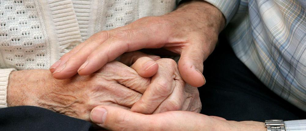 Mann hält die Hand seiner Frau.