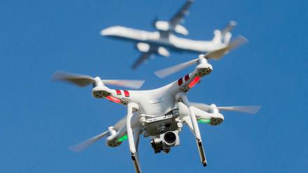 Eine private Drohne fliegt in Nordrhein-Westfalen, im Hintergrund ist ein Flugzeug beim Anflug auf den Flughafen Düsseldorf zu sehen. 