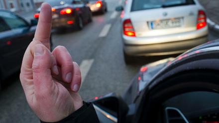 Autofahrer zeigt "Stinkefinger" aus seinem Auto. 