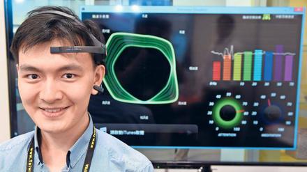 EEG für zu Hause. Das Headset der Firma NeuroSky (hier bei einer Messepräsentation in Taiwan) misst die Hirnstromwellen. Wenn der gewünschte Zustand erreicht ist, bekommt der Spieler eine Rückmeldung – zum Beispiel über ein grafisches Element auf dem Bildschirm.